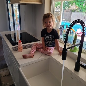 toddler playing with Moen Align MotionSense faucet technology